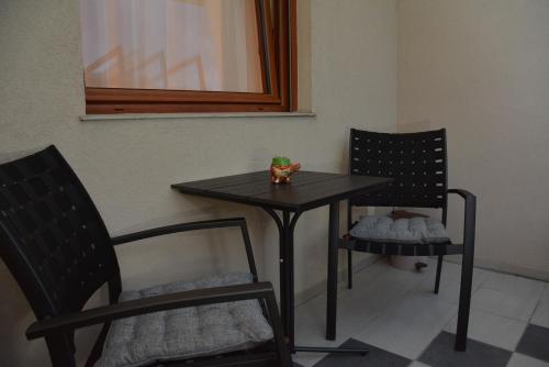 a black table and two chairs and a table and chairs at Apartman Favorito 327 in Vrnjačka Banja