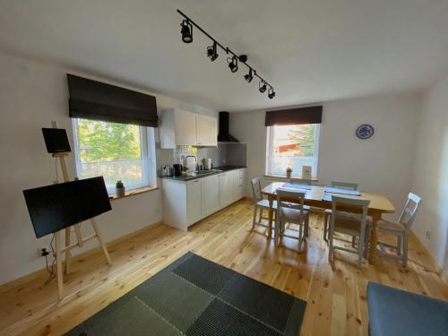 a kitchen and dining room with a table and chairs at Komoda Tykocin in Tykocin