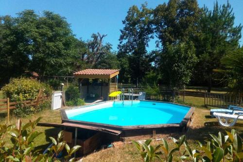 - une piscine dans une cour avec un kiosque dans l'établissement Villa landaise, à Pouydesseaux