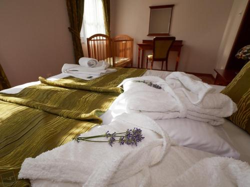 a bed with towels and flowers on top of it at Hradná stráž Hotel&Apartments s privátnym wellness in Topoľčianky