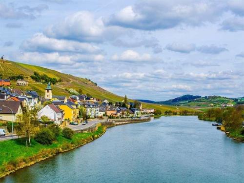 a town next to a river with a city at Cozy flat near Moselle Remich in Remich
