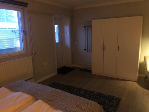 a bedroom with a bed and a cabinet and a window at Hotell Åre Fjällsätra in Undersåker