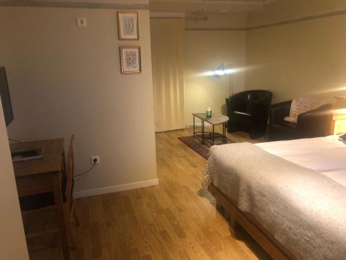 a bedroom with a bed and a living room with a couch at Hotell Åre Fjällsätra in Undersåker