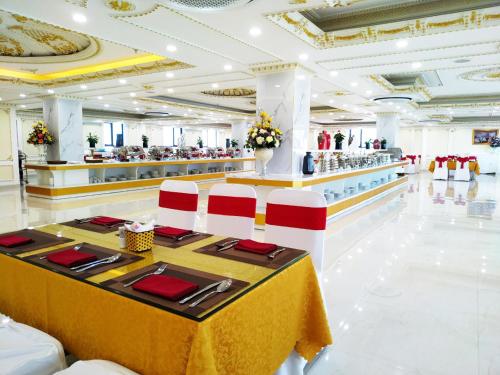 a restaurant with a table with red and white chairs at Khách Sạn Phượng Hoàng 3 in Thanh Hóa