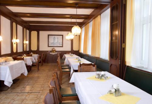 a row of tables in a restaurant with white linens at Hotel zur Sonne in Korneuburg