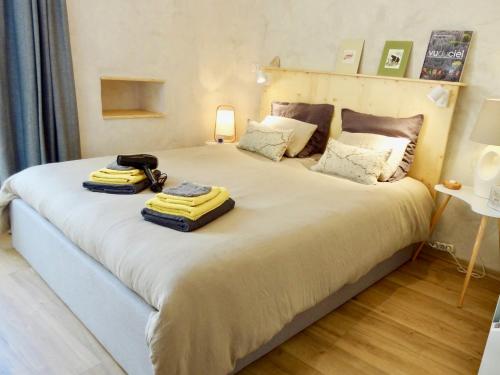 a bedroom with a large bed with two towels on it at La Couette Enchantée - Parking - Zimmerbach in Zimmerbach