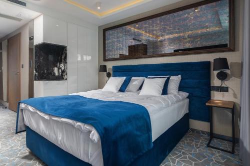 a large bed in a room with a blue head board at Love Sopot Residence in Sopot