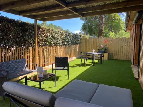 a patio with a couch and chairs and a table at La Cabane d'Arès - chambre double PREMIUM in Arès