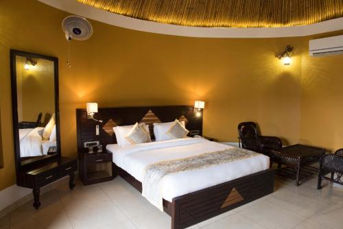 a bedroom with a large bed and a mirror at Sun Hotel and Resort, Mount Abu in Ābu Road