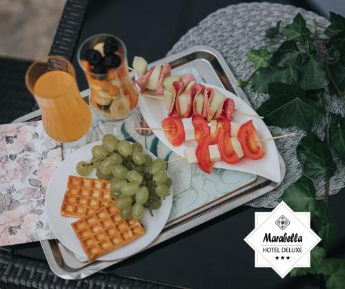 a tray of food with hot dogs and grapes at Hotel Marabella in Sibiu