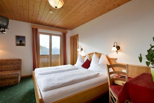 A bed or beds in a room at Alpengasthof Hirschberg