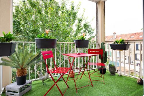 a balcony with red chairs and potted plants at T2 proche Disneyland Paris in Meaux