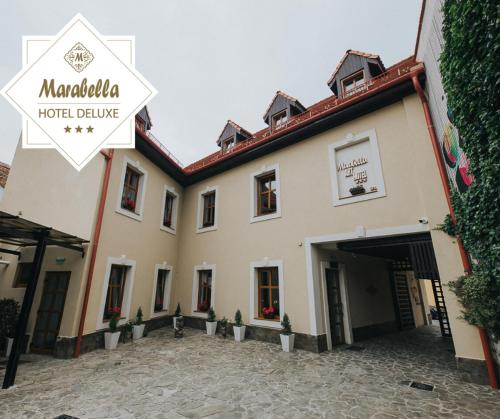 a hotel building with a courtyard in front of it at Hotel Marabella in Sibiu