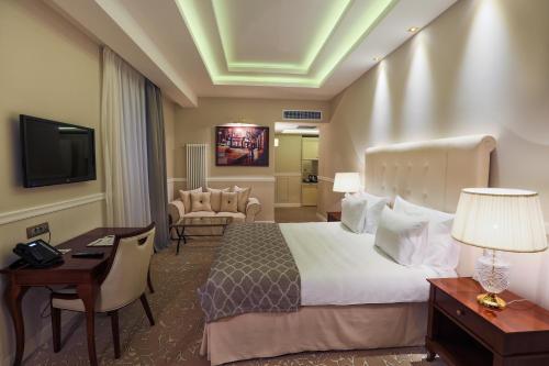 a hotel room with a bed and a desk and a television at Hotel International Iasi in Iaşi