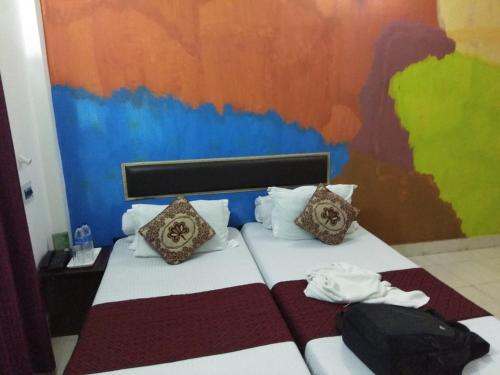 a bedroom with a bed with a colorful wall at Mystic resort amidst Tea Garden in Mādāri Hāt