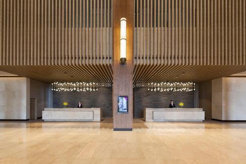 a lobby with two people sitting at reception desks at Crowne Plaza Hangzhou Thousand Island Lake by IHG in Thousand Island Lake