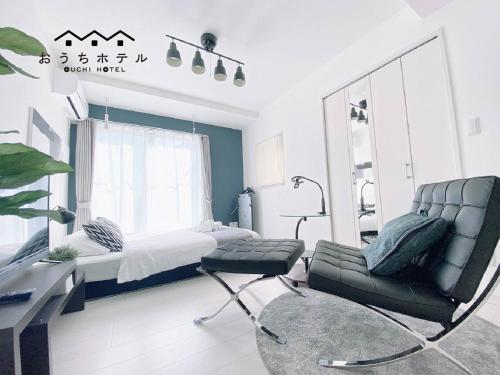 a bedroom with a bed and a chair at OUCHI HOTEL Hatsukaichi-Ekimae in Hatsukaichi