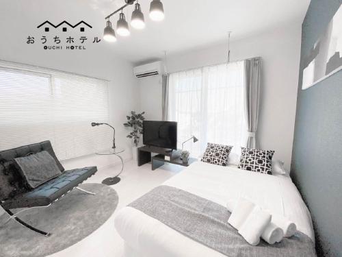 a bedroom with a bed and a chair and a television at OUCHI HOTEL Hatsukaichi-Ekimae in Hatsukaichi