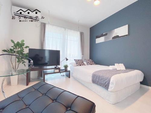 a bedroom with a bed and a tv in it at OUCHI HOTEL Hatsukaichi-Ekimae in Hatsukaichi