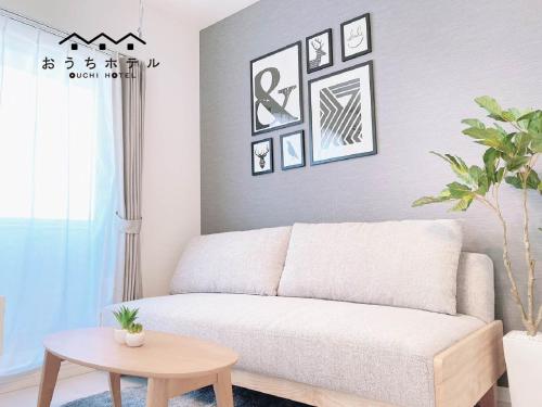 a living room with a couch and a table at OUCHI HOTEL Hatsukaichi-Ekimae in Hatsukaichi