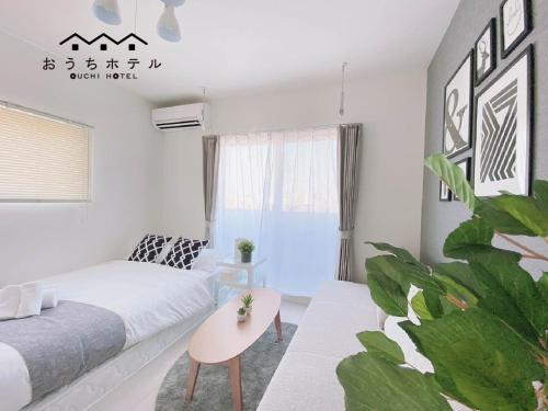 a living room with a bed and a plant at OUCHI HOTEL Hatsukaichi-Ekimae in Hatsukaichi
