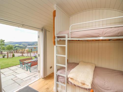 a bedroom with bunk beds and a balcony at Hillside View in Saint Harmon