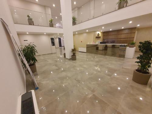 an empty lobby with potted plants in a building at Amber Hotel Albania in Spille