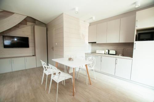 - une cuisine avec une table et des chaises dans la chambre dans l'établissement Domki Amber House, à Dźwirzyno
