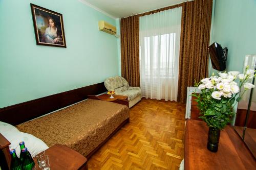 a hotel room with a bed and a vase of flowers at Sanatoriy Kirova in Pyatigorsk