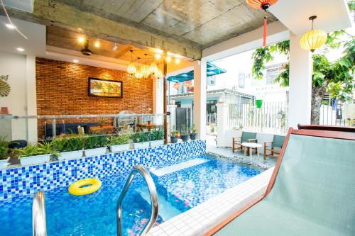an indoor pool with a slide and a frisbee at HOI AN HEART LODGE in Hoi An
