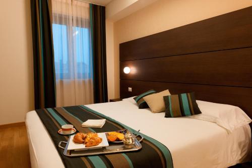 a hotel room with a tray of food on a bed at HB Aosta Hotel & Balcony SPA in Aosta