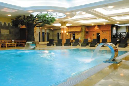 a large swimming pool in a hotel lobby at GRINN HOTEL & SPA in Oryol