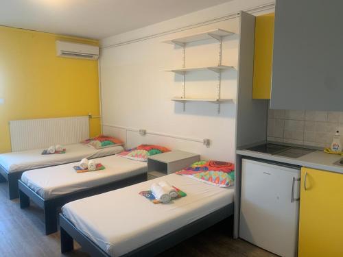 um grupo de quatro camas num quarto em ŠD Portorož Hostel Korotan em Portorož