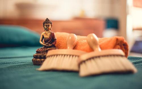 a small statue of a buddha sitting next to a brush at deinFerienhaus Scheliga „Midi“ in Bad Sobernheim