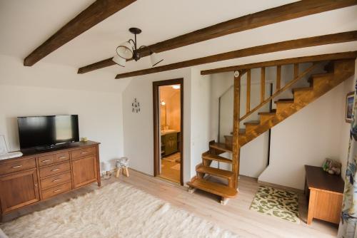 a living room with a staircase and a flat screen tv at Vila Chic M in Moieciu de Jos