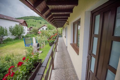 a balcony of a house with flowers on it at Vila Chic M in Moieciu de Jos