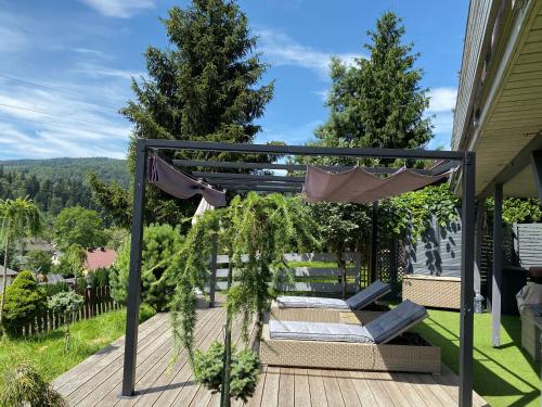 a deck with a hammock and plants on a house at Kwaterka in Brenna