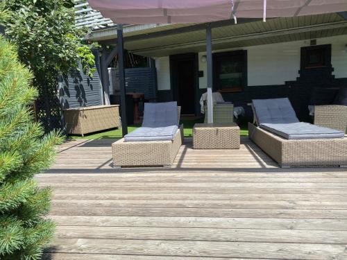 a deck with chairs and an umbrella on a house at Kwaterka in Brenna