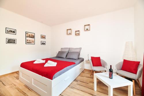 a white bedroom with a bed and two chairs at Apartment Piccolo in Umag
