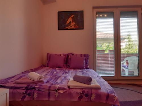 a large purple bed in a room with a window at Lili in Arandjelovac