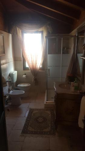 a bathroom with a sink and a toilet and a window at BeB Villa Sorriso in San Benedetto Val di Sambro