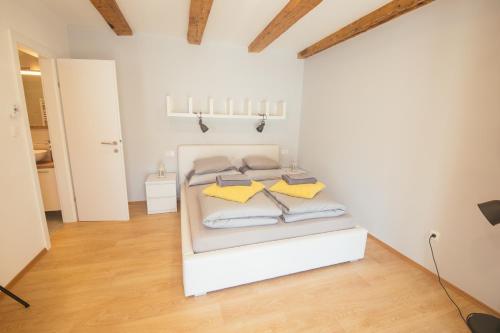 een slaapkamer met een wit bed met gele kussens bij Apartment 63 - 3 in Zagreb