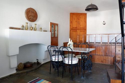 jadalnia ze stołem i kominkiem w obiekcie Asiminas House w mieście Simi