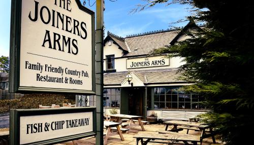 um grupo de mesas de piquenique em frente a um restaurante em The Joiners Arms em Chathill