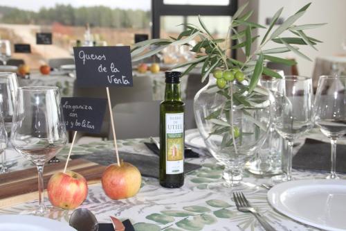 a bottle of wine sitting on a table with glasses at Hotel rural Entreviñas in Caudete de las Fuentes