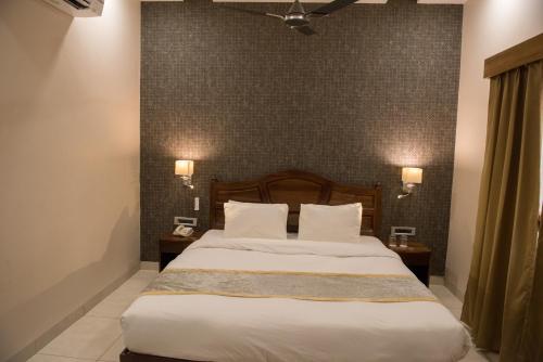 a bedroom with a large bed with two night stands at Sun Hotel and Resort, Mount Abu in Ābu Road