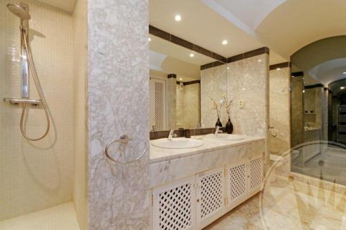 een badkamer met 2 wastafels, een douche en een bad bij La Manga Club Resort - Las Palmeras 483 in Atamaría