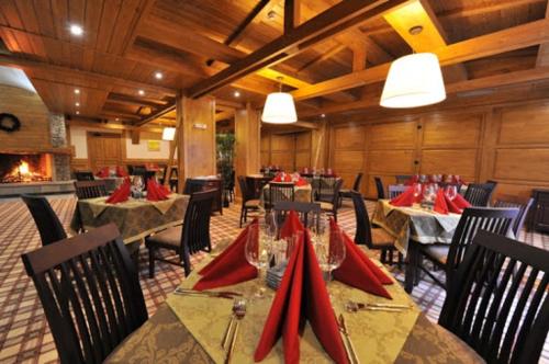 un restaurant avec des tables, des chaises et des serviettes rouges dans l'établissement Lake View House, à Bansko