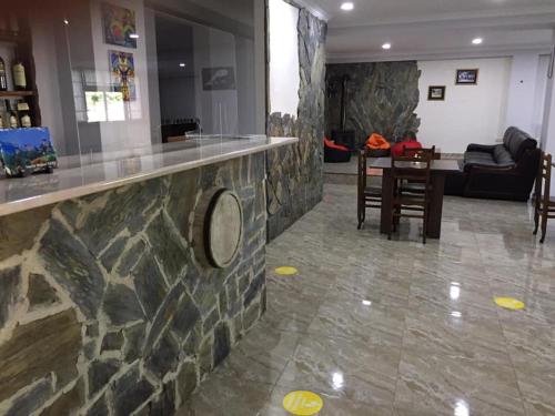 a kitchen and living room with a stone wall at Guesthouse Gera in Mestia