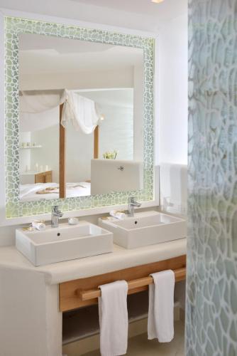 a bathroom with two sinks and a mirror at Petinos Hotel in Platis Yialos Mykonos